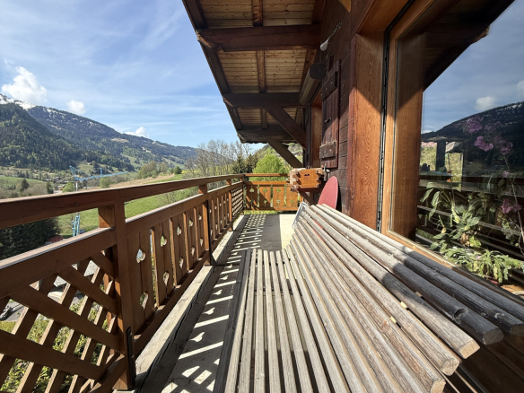 Wooden balcony of a traditional chalet with mountain views in Megève.
