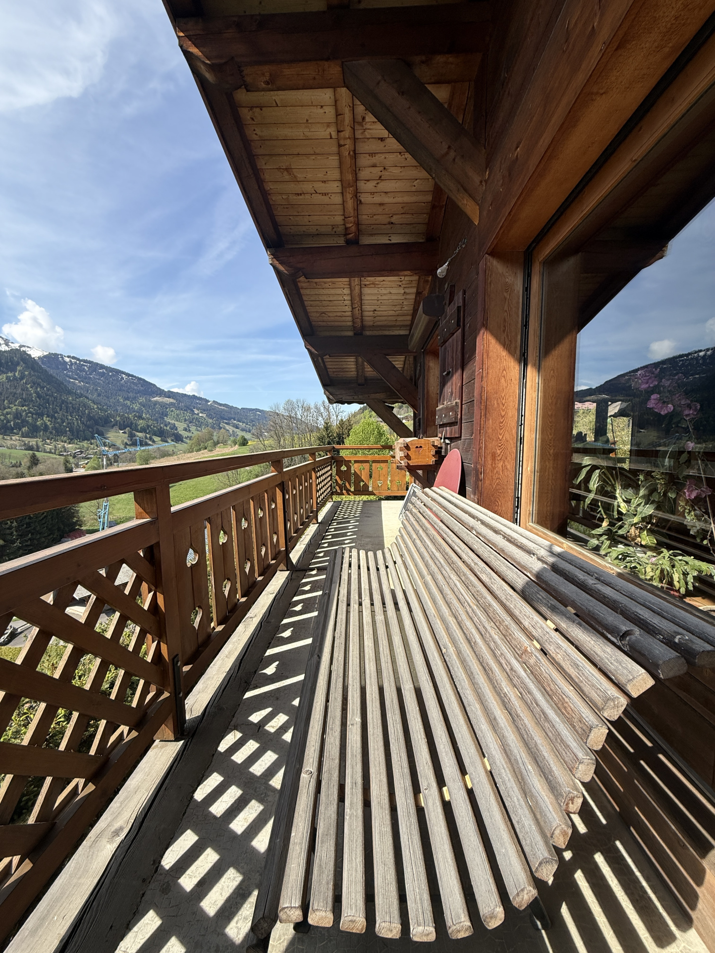 Wooden balcony of a traditional chalet with mountain views in Megève.