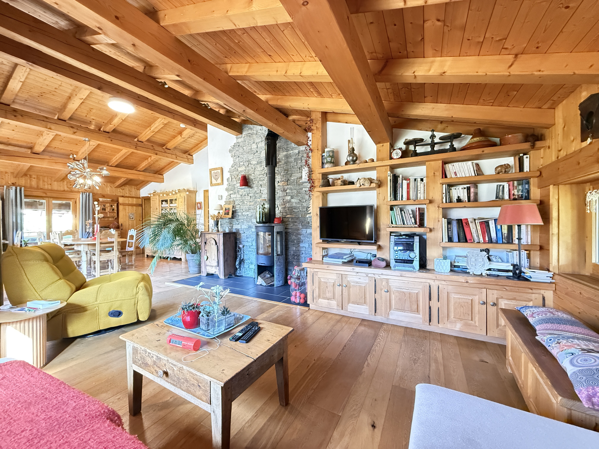 Interior of a traditional chalet with a wooden living room, fireplace and warm furnishings.