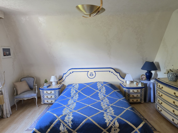 Chambre à coucher décorée avec un lit bleu et des meubles assortis, lumière naturelle.
