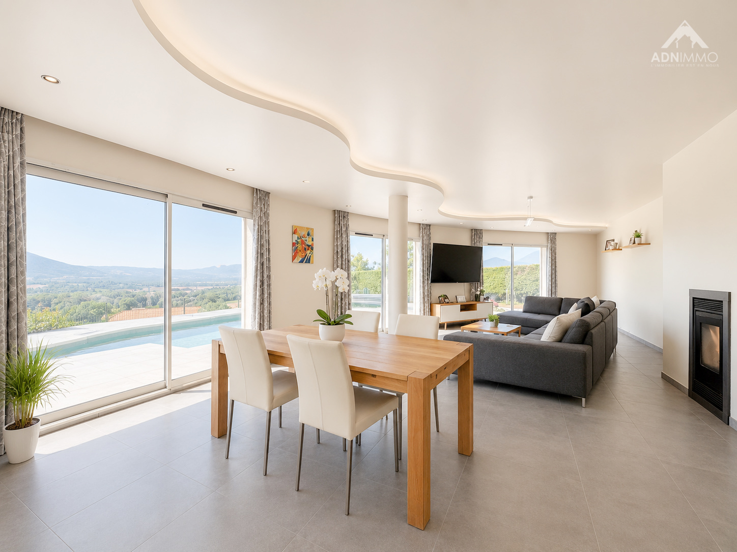 Espace de vie lumineux dans une maison à Challex Intérieur d'une maison moderne avec espace de vie lumineux, table à manger et vue sur la nature.