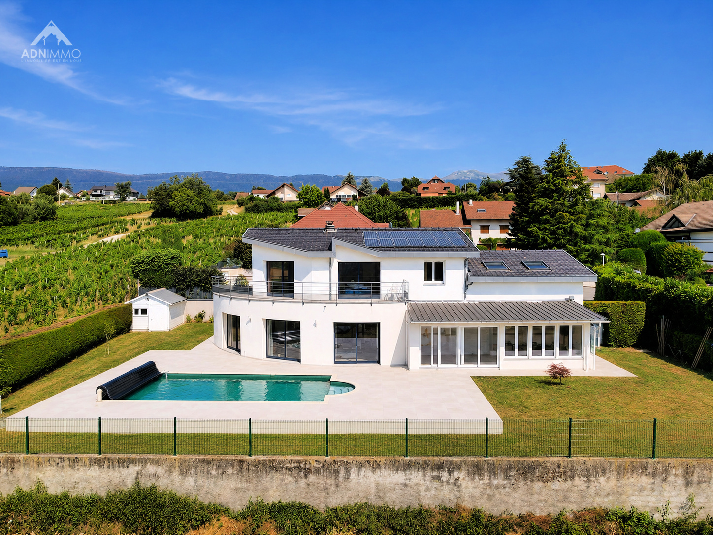 Maison individuelle à Challex Maison individuelle moderne avec piscine à Challex, vue sur le jardin et les montagnes.