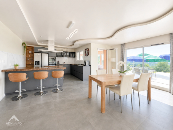 Intérieur d'une maison moderne avec cuisine ouverte, bar et salle à manger.
