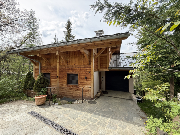 Alpine wooden chalet with garage, surrounded by greenery in Combloux.