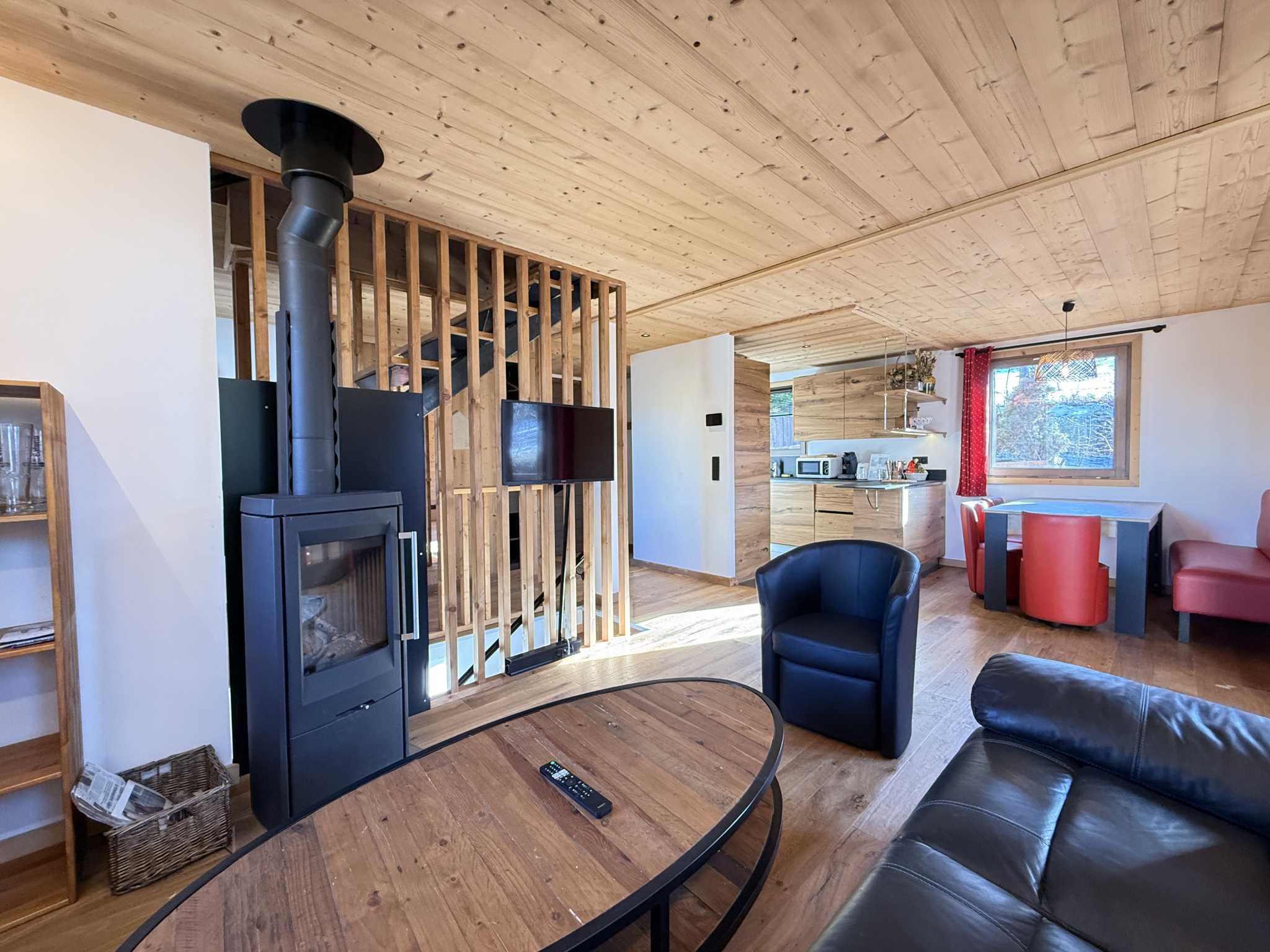 Interior of an alpine chalet in Combloux Interior of an alpine chalet in Combloux, with a wood-burning stove, a living room and an open kitchen.