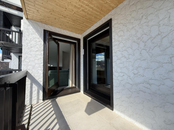 Balcony of an apartment in the Les Mandarines condominium in Megève, with views of the surrounding landscape.