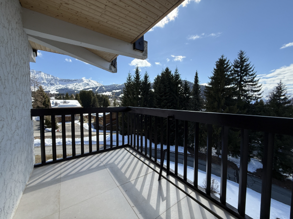 Balcon d'un appartement avec vue sur les montagnes et la forêt, à Megève.