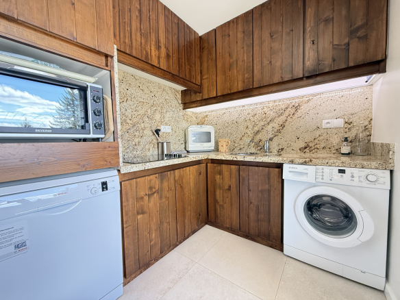 Cuisine équipée avec plan de travail en granit et appareils électroménagers dans un appartement.
