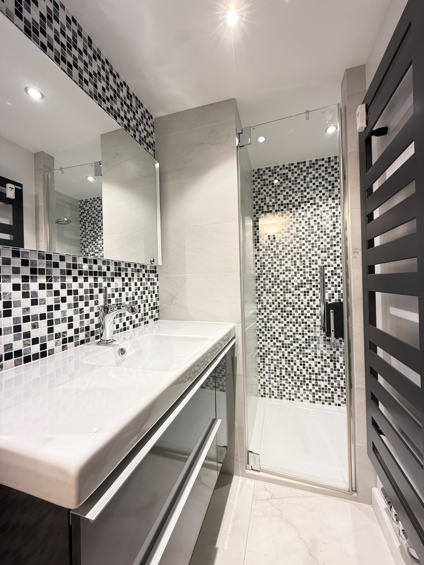 Salle de bain moderne à Megève Salle de bain moderne avec douche et lavabo dans un appartement.