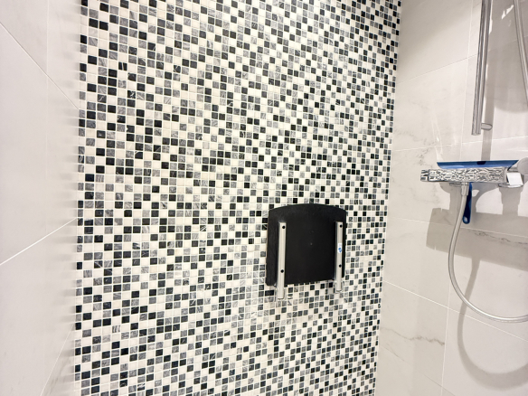 Douche avec carrelage en mosaïque noir et blanc dans un appartement.