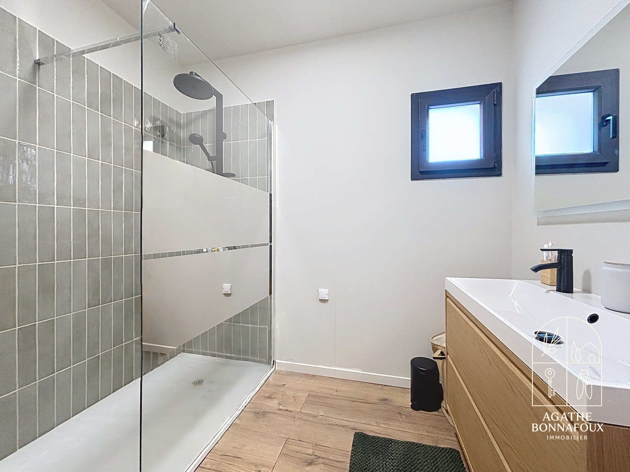 Modern bathroom with walk-in shower and wooden vanity.