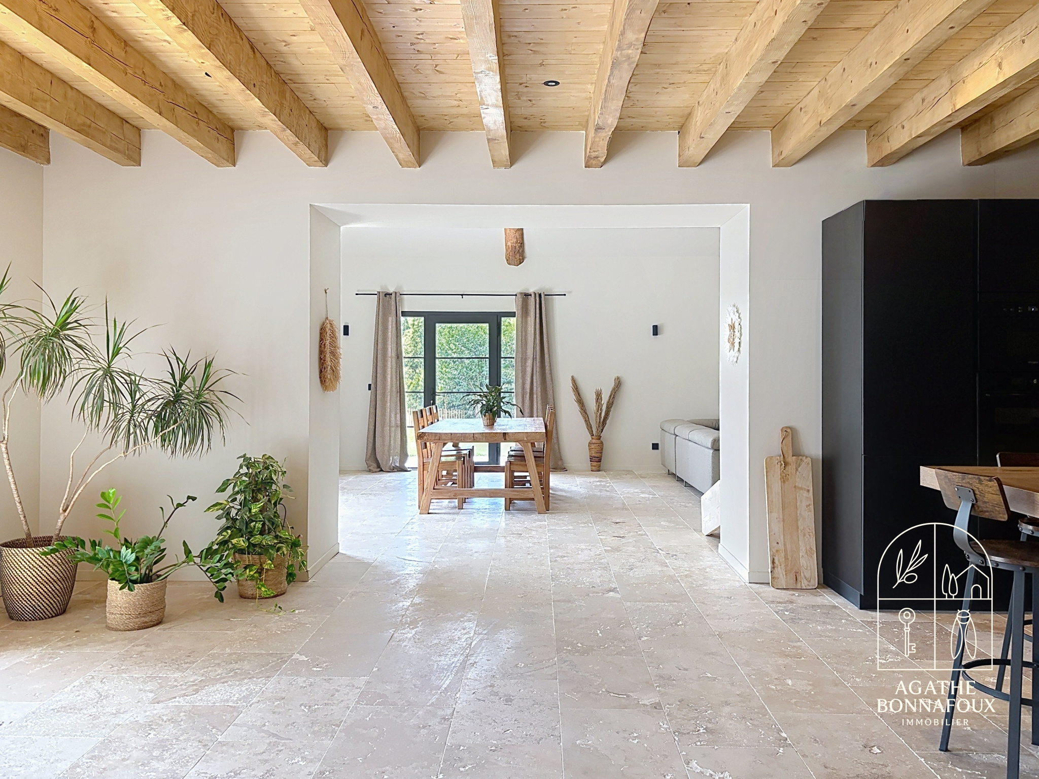 Interior of a renovated Provençal farmhouse with exposed beams and modern furniture.