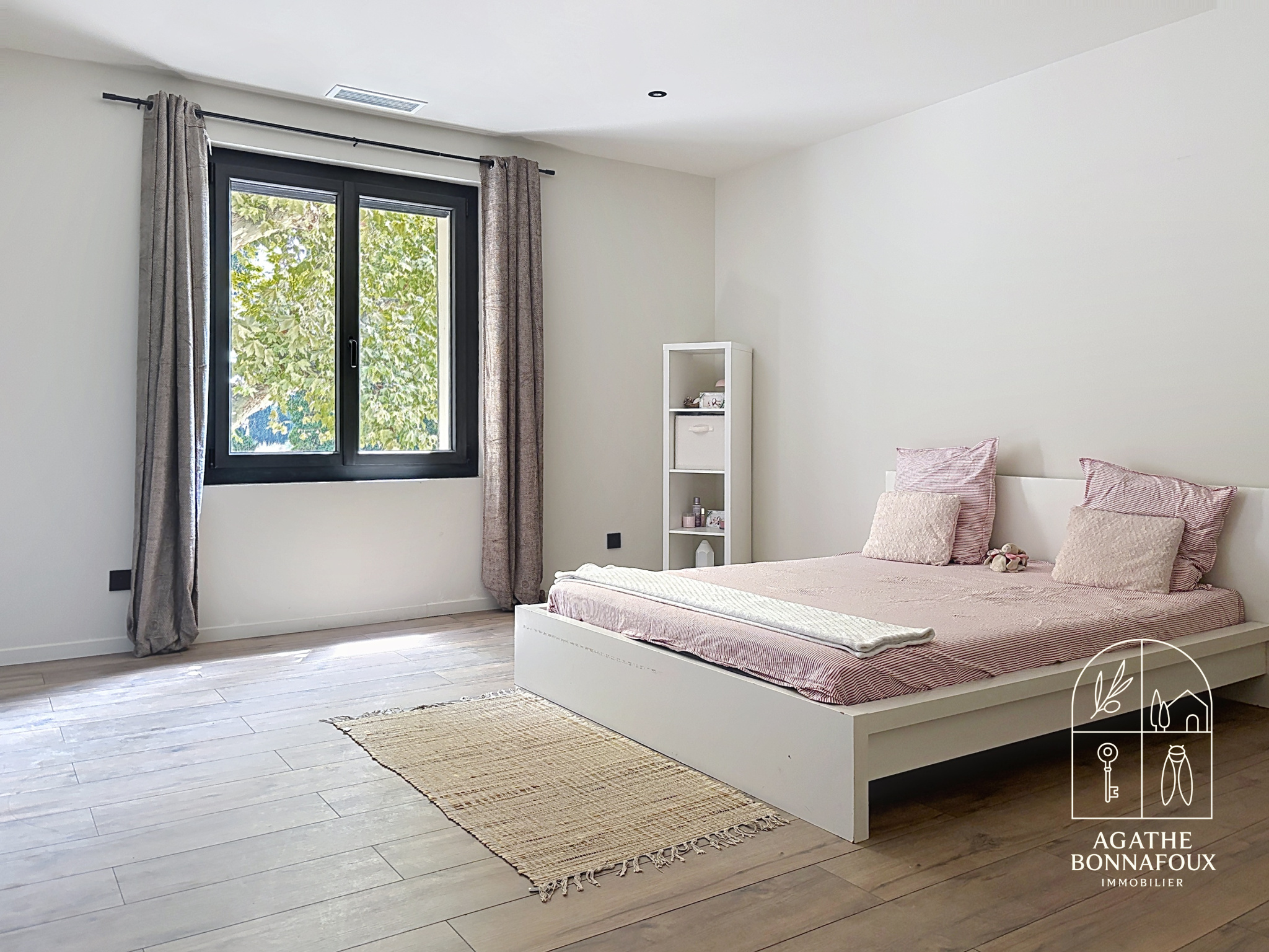 Room in a renovated Provençal farmhouse with a double bed and windows overlooking the outside.