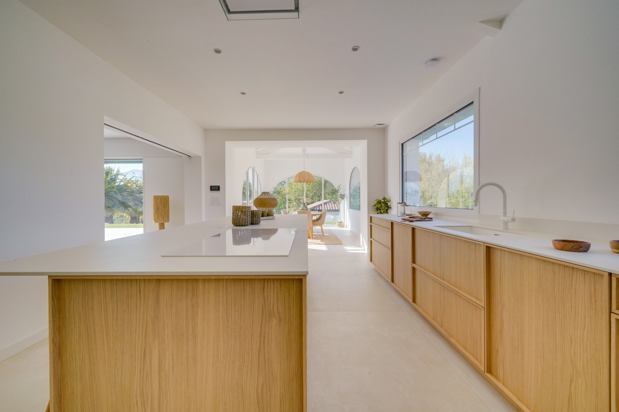 Cuisine moderne dans une maison à Urrugne Cuisine moderne et lumineuse avec îlot central et vue sur l'extérieur.