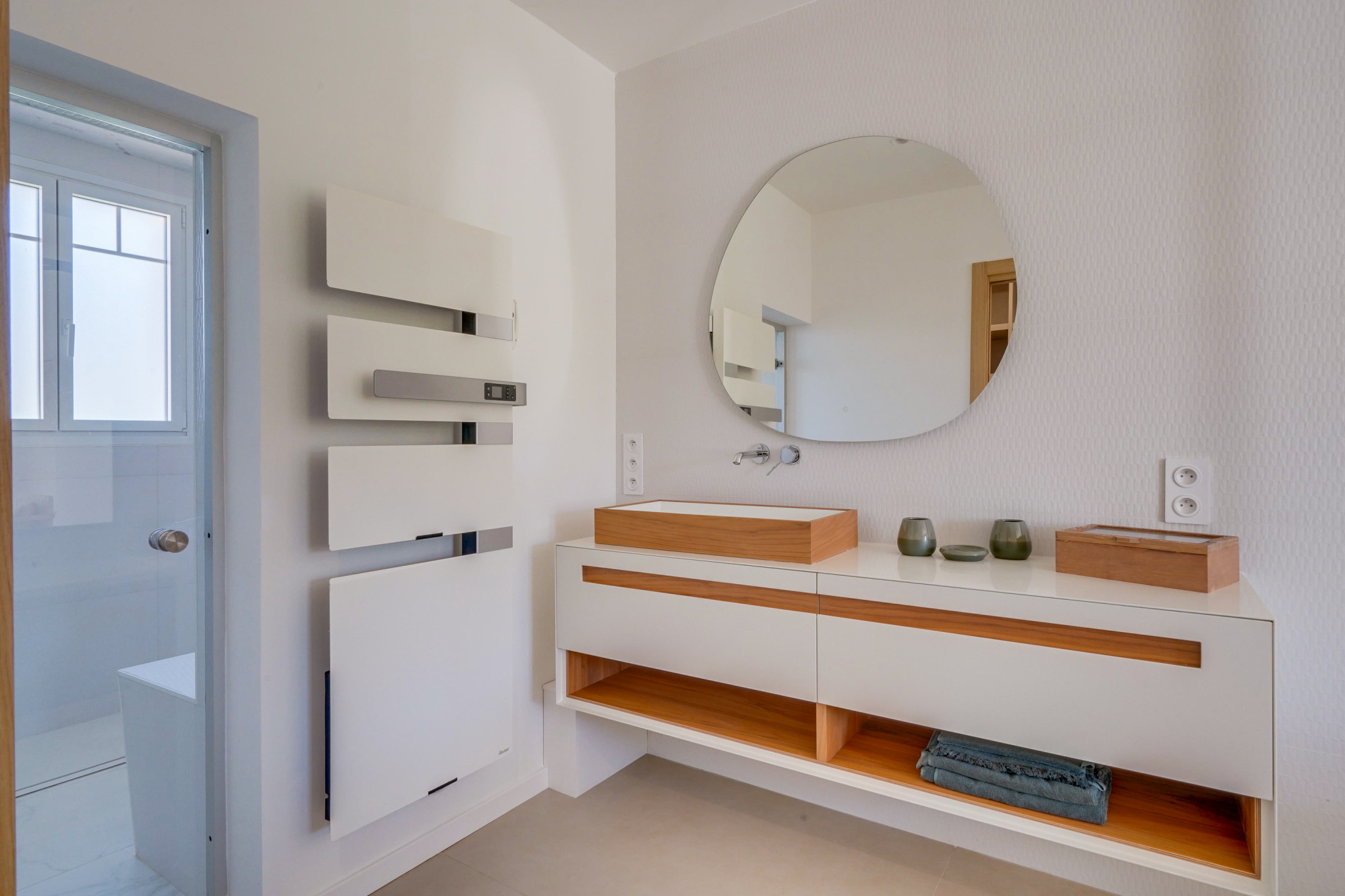 Salle de bain moderne Salle de bain moderne avec meuble en bois et miroir ovale.
