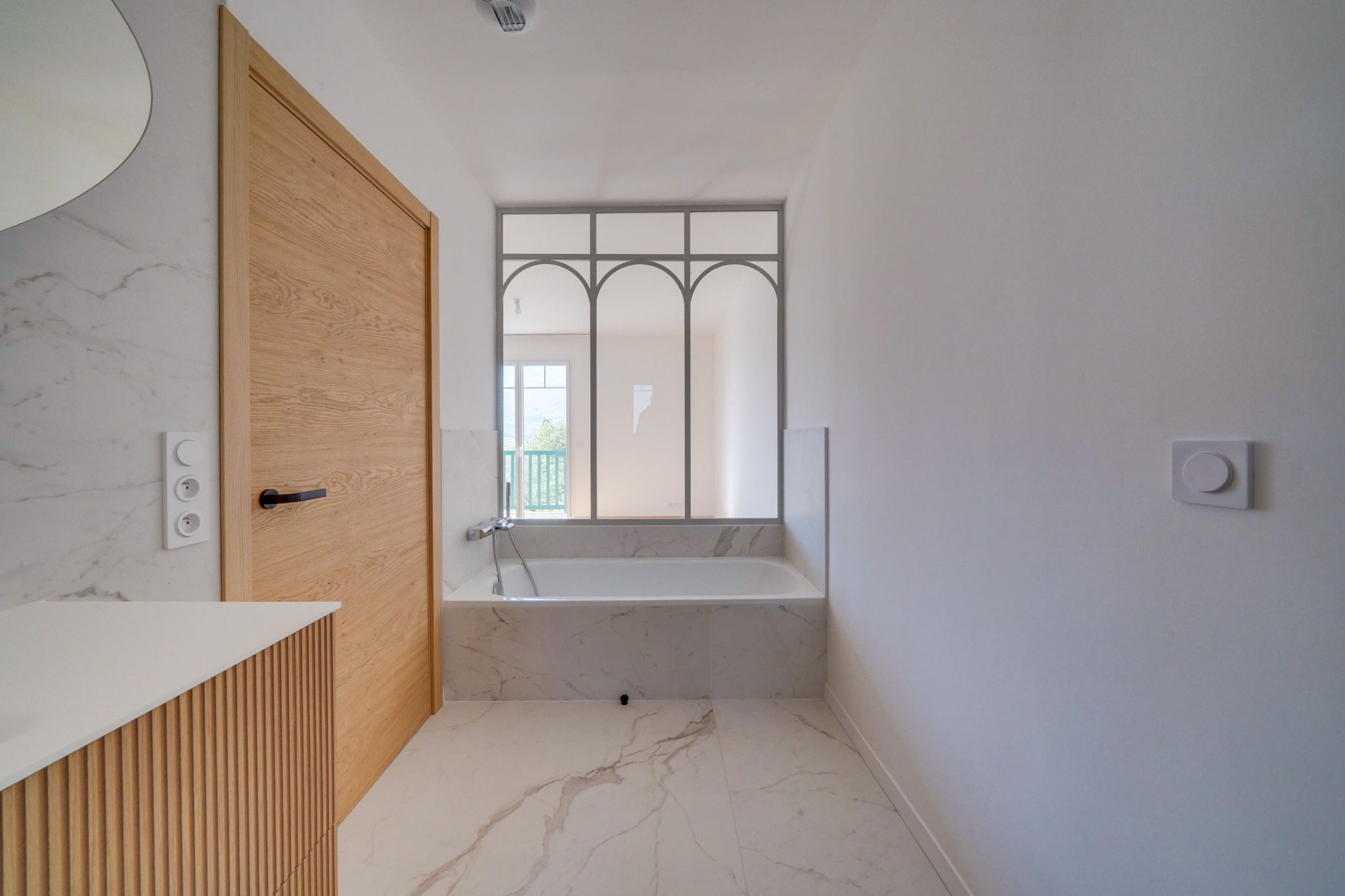 Salle de bain moderne Salle de bain moderne avec baignoire et miroir décoratif en marbre.