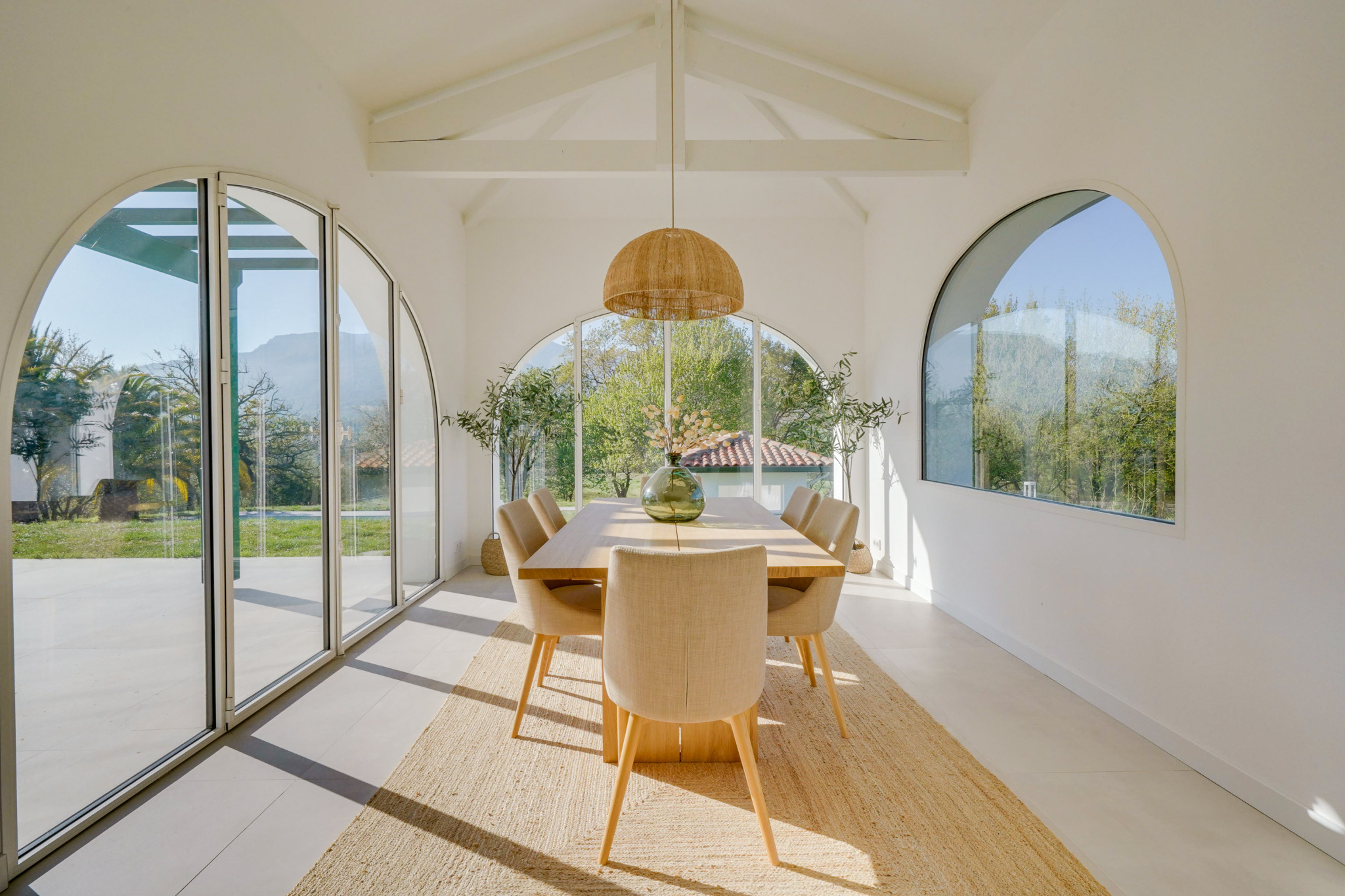 Salle à manger moderne dans une maison à Urrugne Intérieur d'une maison moderne avec salle à manger lumineuse et grandes fenêtres.