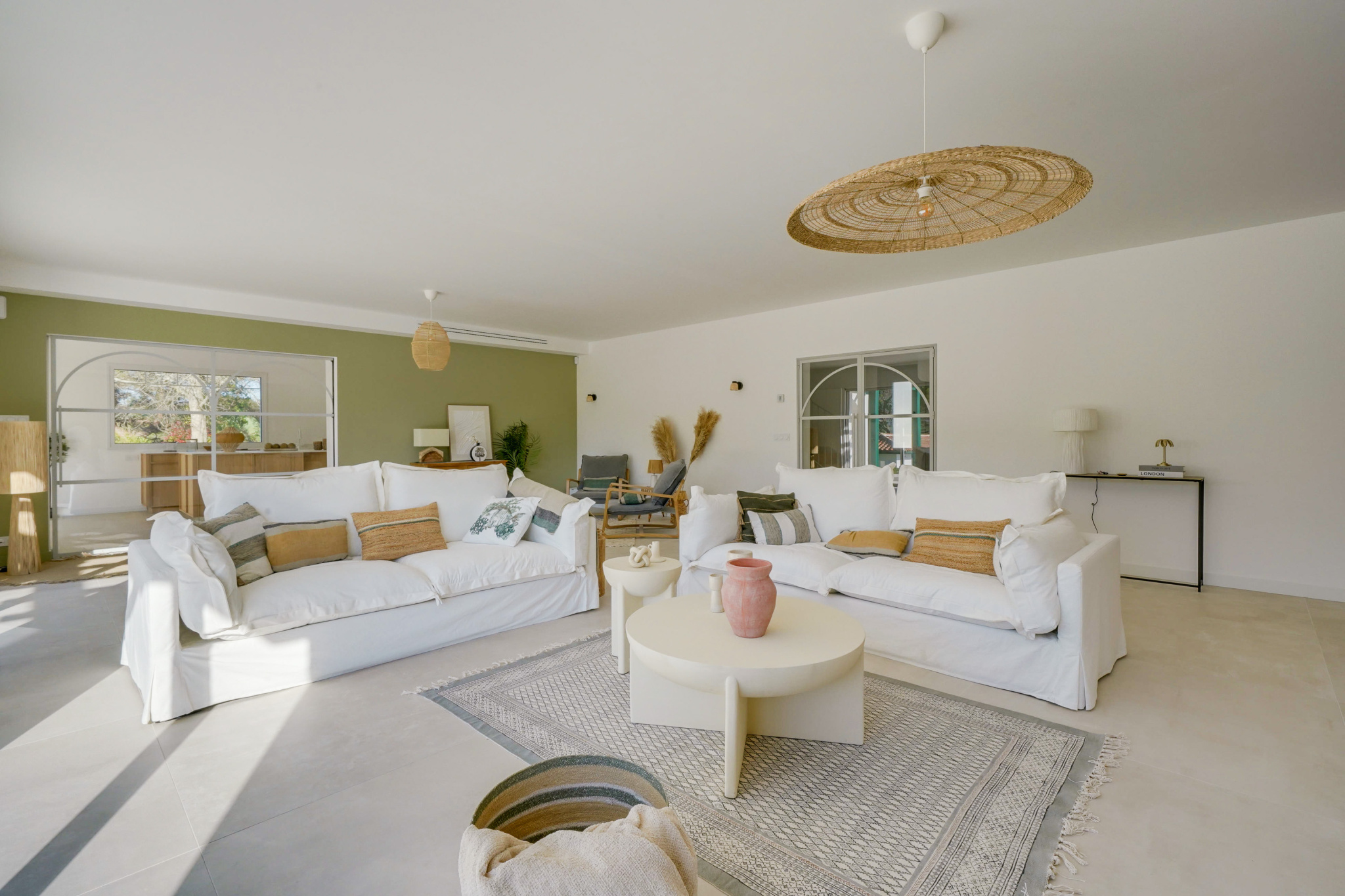 Salon d’une maison rénovée à Urrugne Intérieur d'une maison rénovée avec salon lumineux, canapés blancs et décoration moderne.