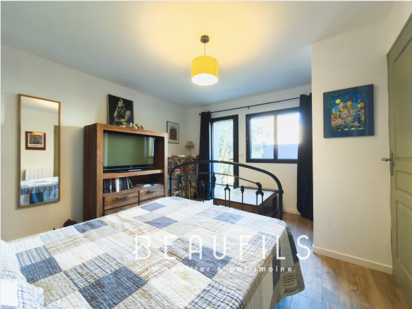 Room in a family villa in Frontignan with bed, television and window overlooking the outside.