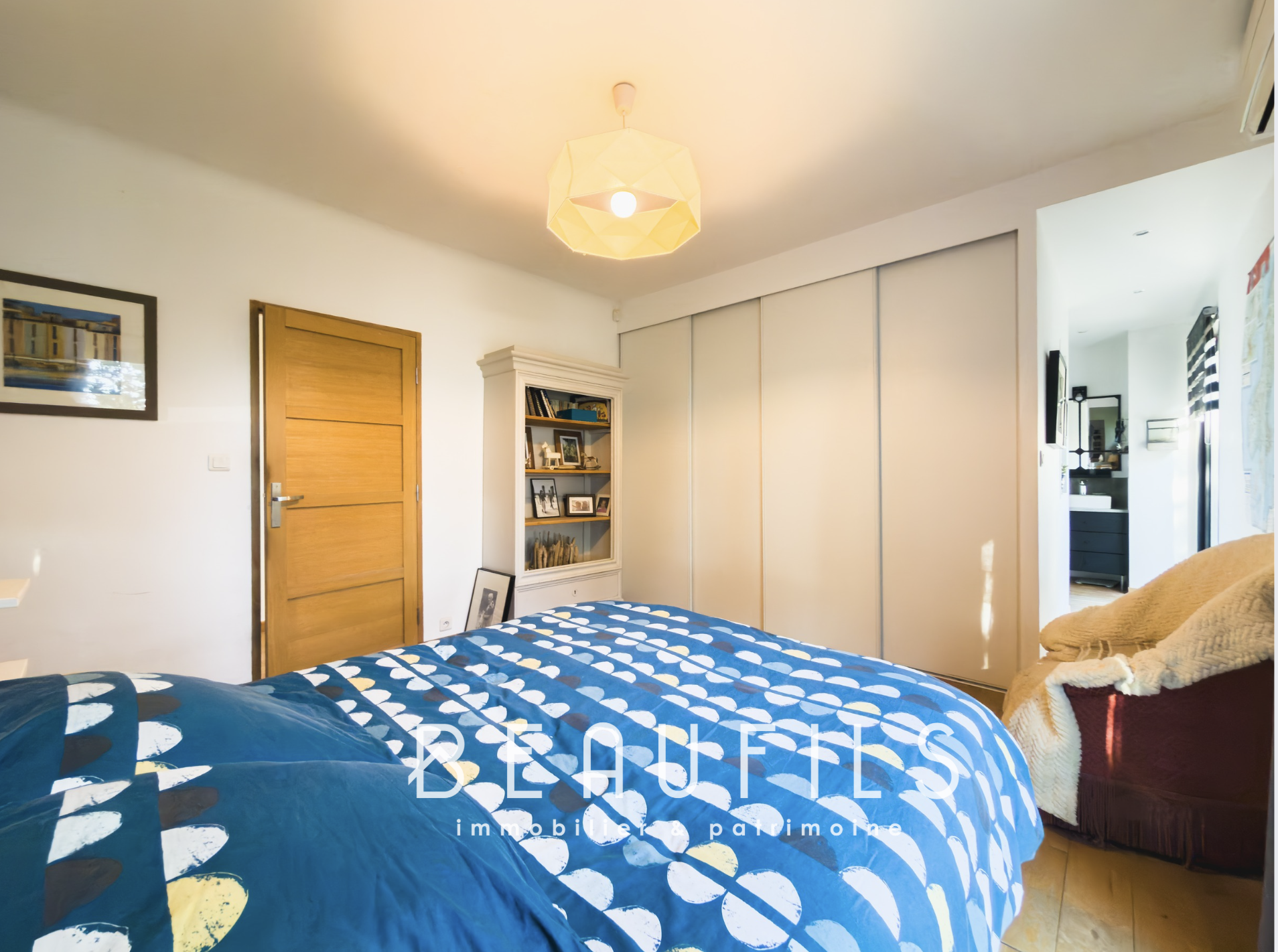 Bedroom in a family villa with bed and storage, decorated in a modern style.