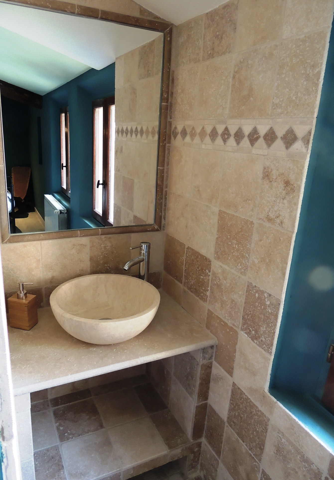 Stone bathroom Bathroom with stone sink and beige tiled walls.