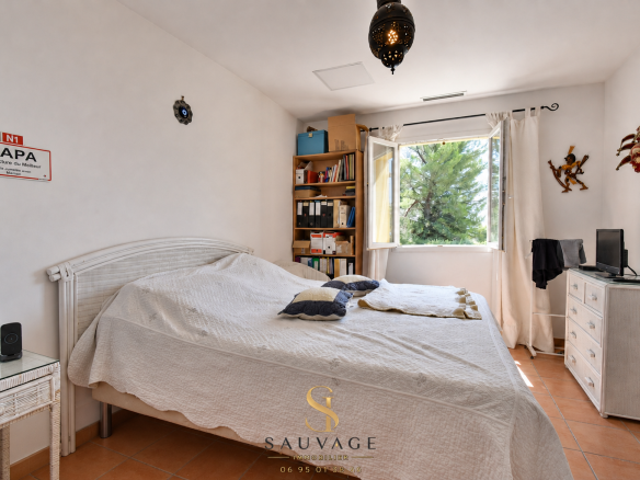 Room in a family country house in Draguignan, with bed, library and window overlooking the outside.