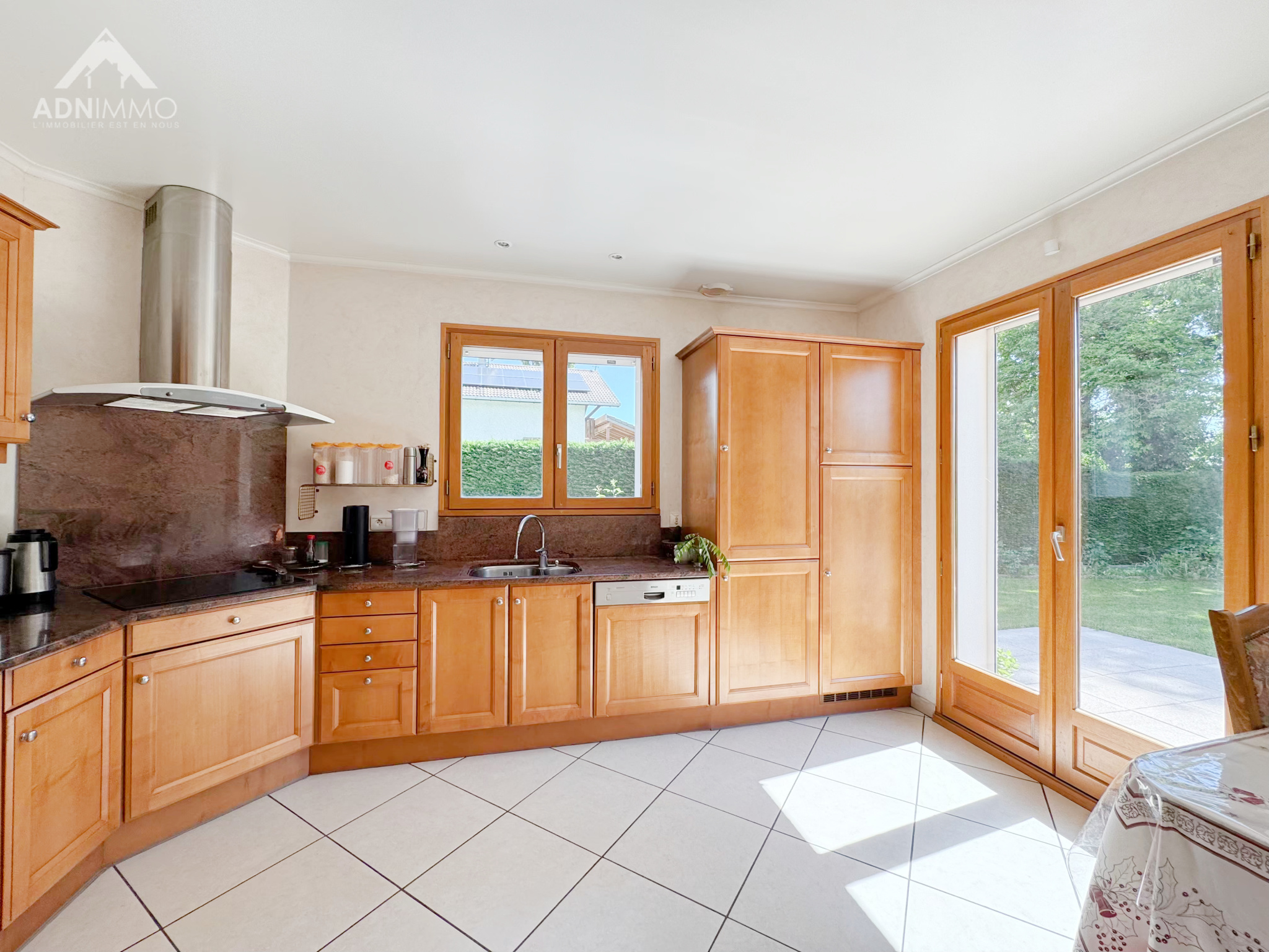 Home cooking in Sergy Fully equipped kitchen with wooden furniture and windows overlooking the outside.