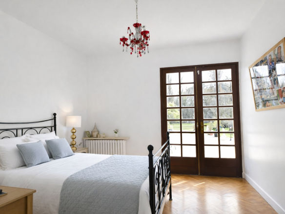 Bright room with bed and French doors opening onto the garden.