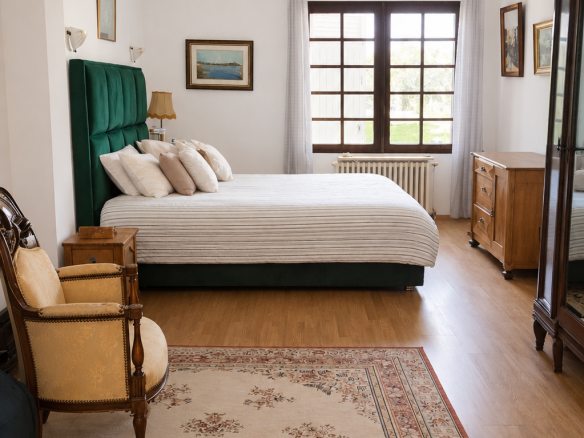 Bright room with double bed, armchair and rug in a house in Gradignan.