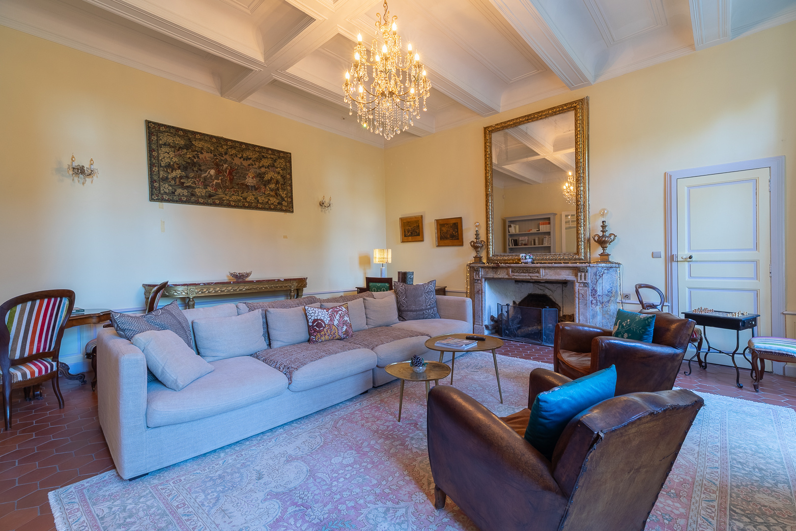 Pézenas Castle Salon Interior of a spacious living room with a sofa, armchairs and a chandelier at Pézenas Castle.