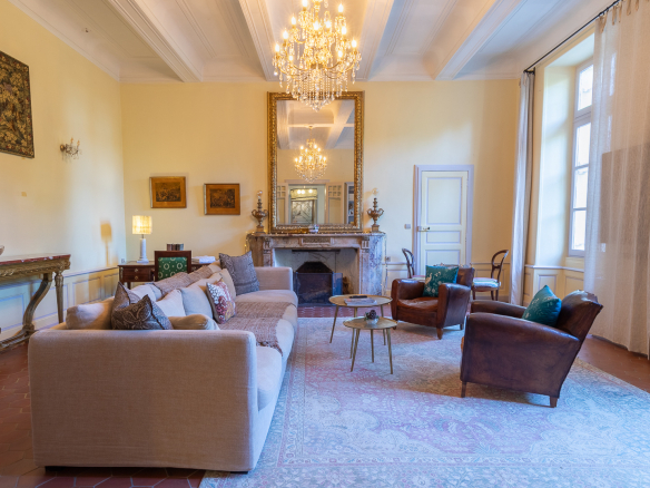 Interior of an elegant living room in a castle, with a sofa, armchairs and a large mirror.