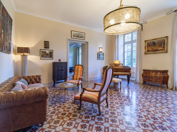 Interior of a castle with a living room, leather sofa, chairs and piano, elegant decor and tiled floor