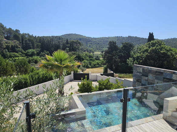 View of the contemporary villa with swimming pool and green landscape in Clermont-l'Hérault.