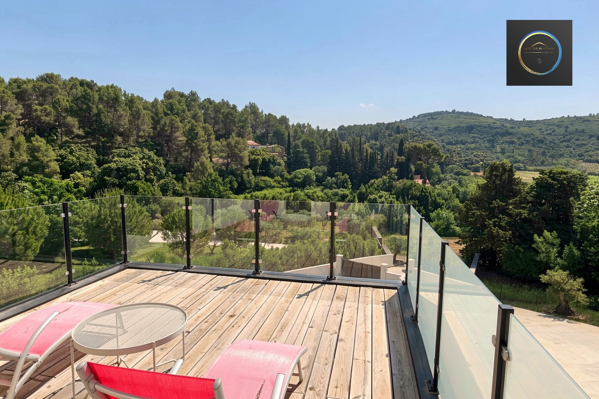 Terrace of a contemporary villa in Clermont-l'Hérault Wooden terrace with deck chairs overlooking a green landscape in Clermont-l'Hérault.