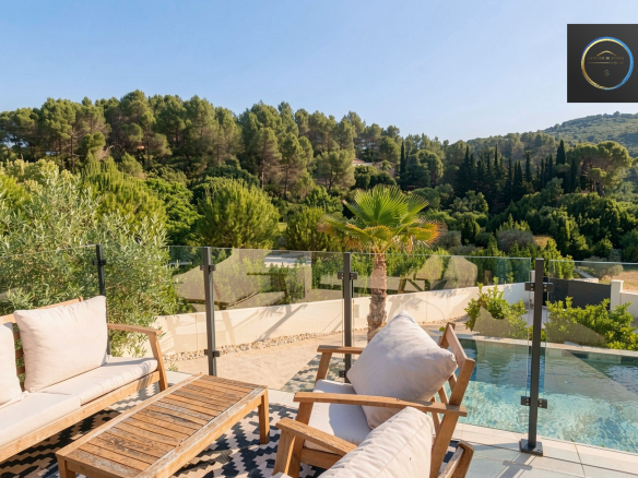 Terrace of a contemporary villa with swimming pool and views of nature in Clermont-l'Hérault.