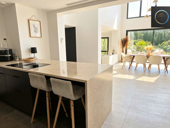 Interior of a contemporary villa with open kitchen and bright dining room in Clermont-l'Hérault.