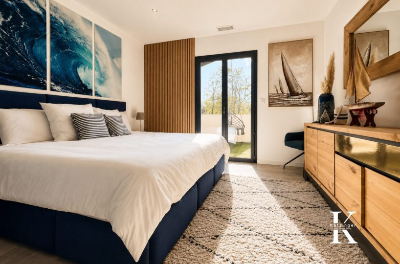 Modern room with king-size bed, nautical decor and access to a balcony.