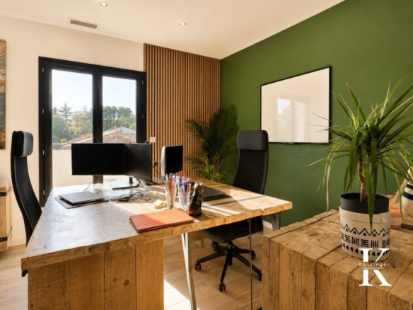Modern office in a contemporary villa with green walls and wooden furniture.
