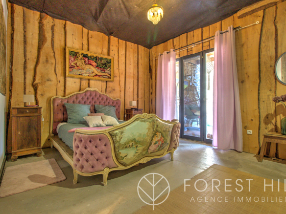 Room decorated with an antique bed and wooden walls in a natural setting.