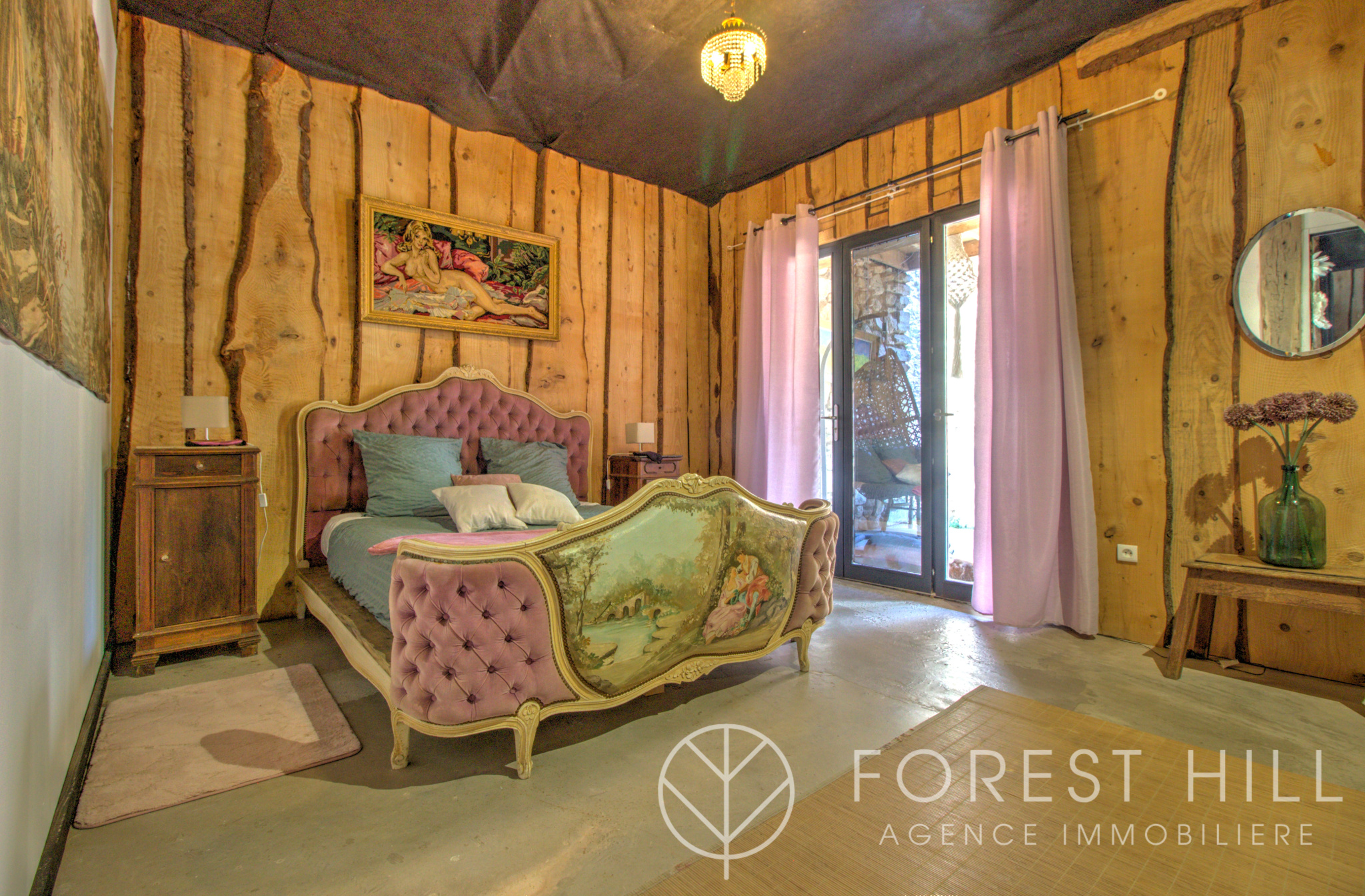 Room decorated with an antique bed and wooden walls in a natural setting.