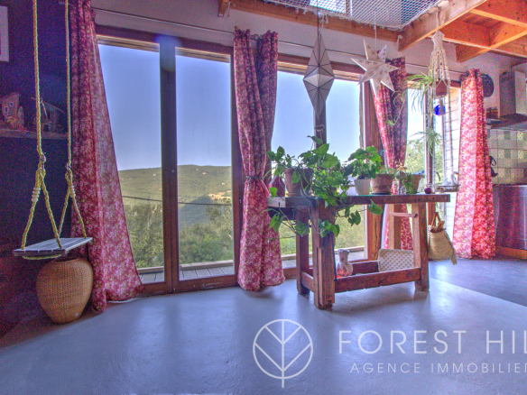 Interior of a house with a view of nature, open windows, plants and warm decoration.