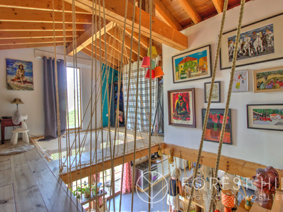 Interior of a property with artwork hanging on the walls and a wooden mezzanine.