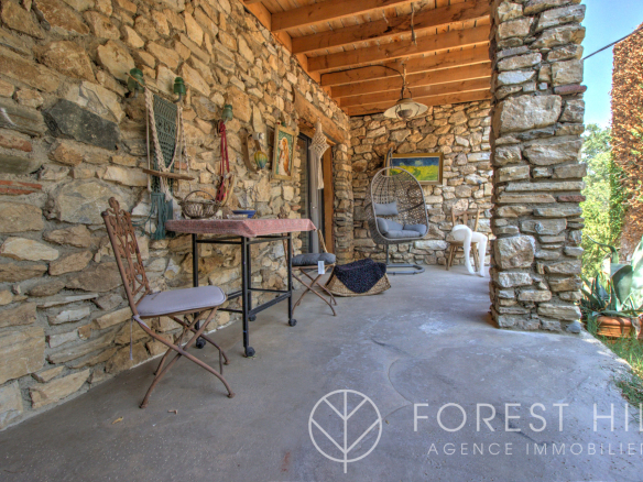 Stone terrace with wrought iron furniture and natural decoration, Montbolo.