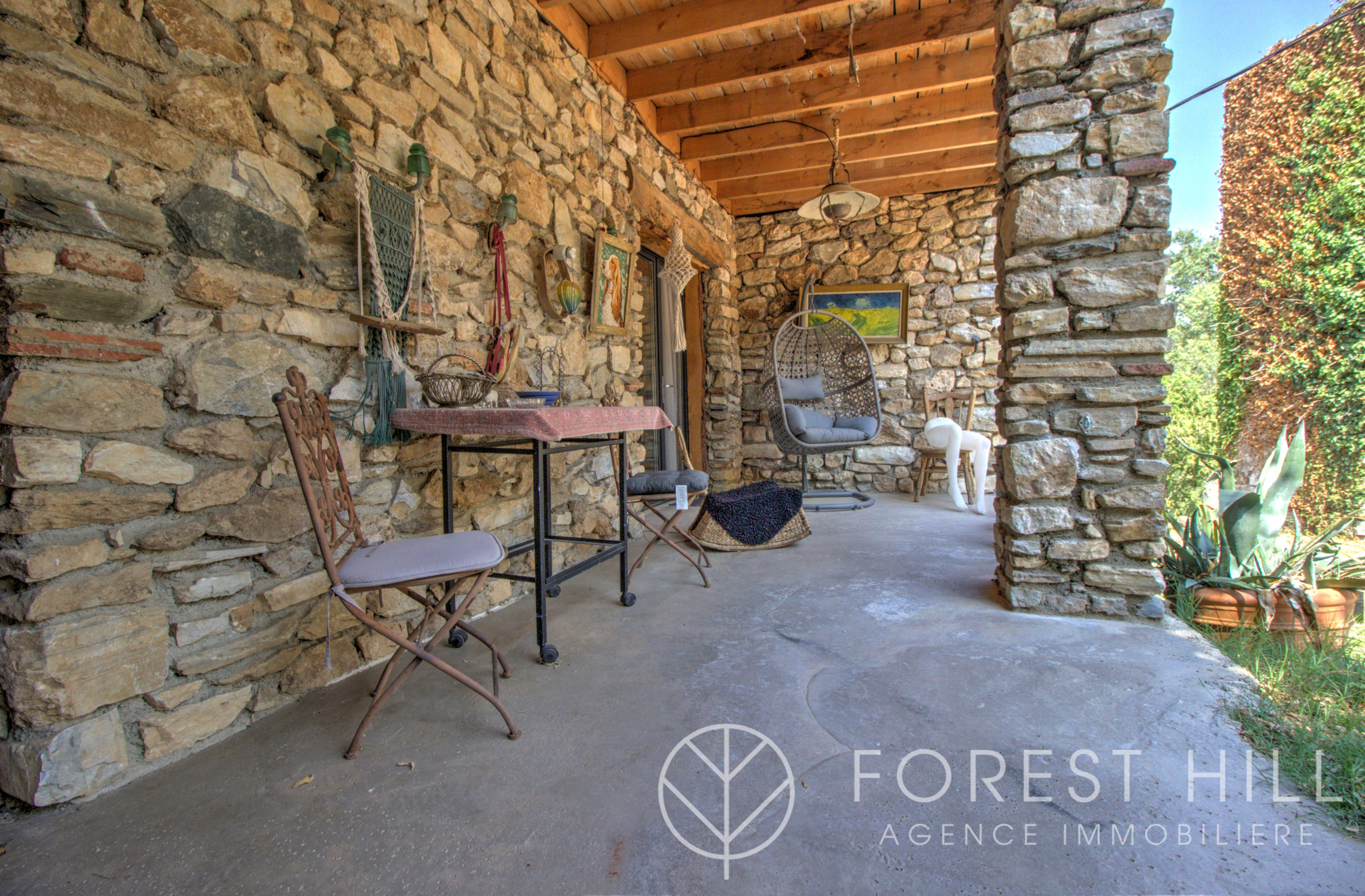 Stone terrace with wrought iron furniture and natural decoration, Montbolo.