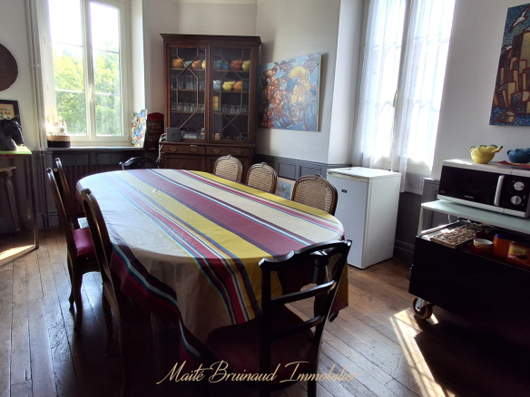 Intérieur d'une maison à Ustaritz avec une grande table à manger et des meubles anciens.