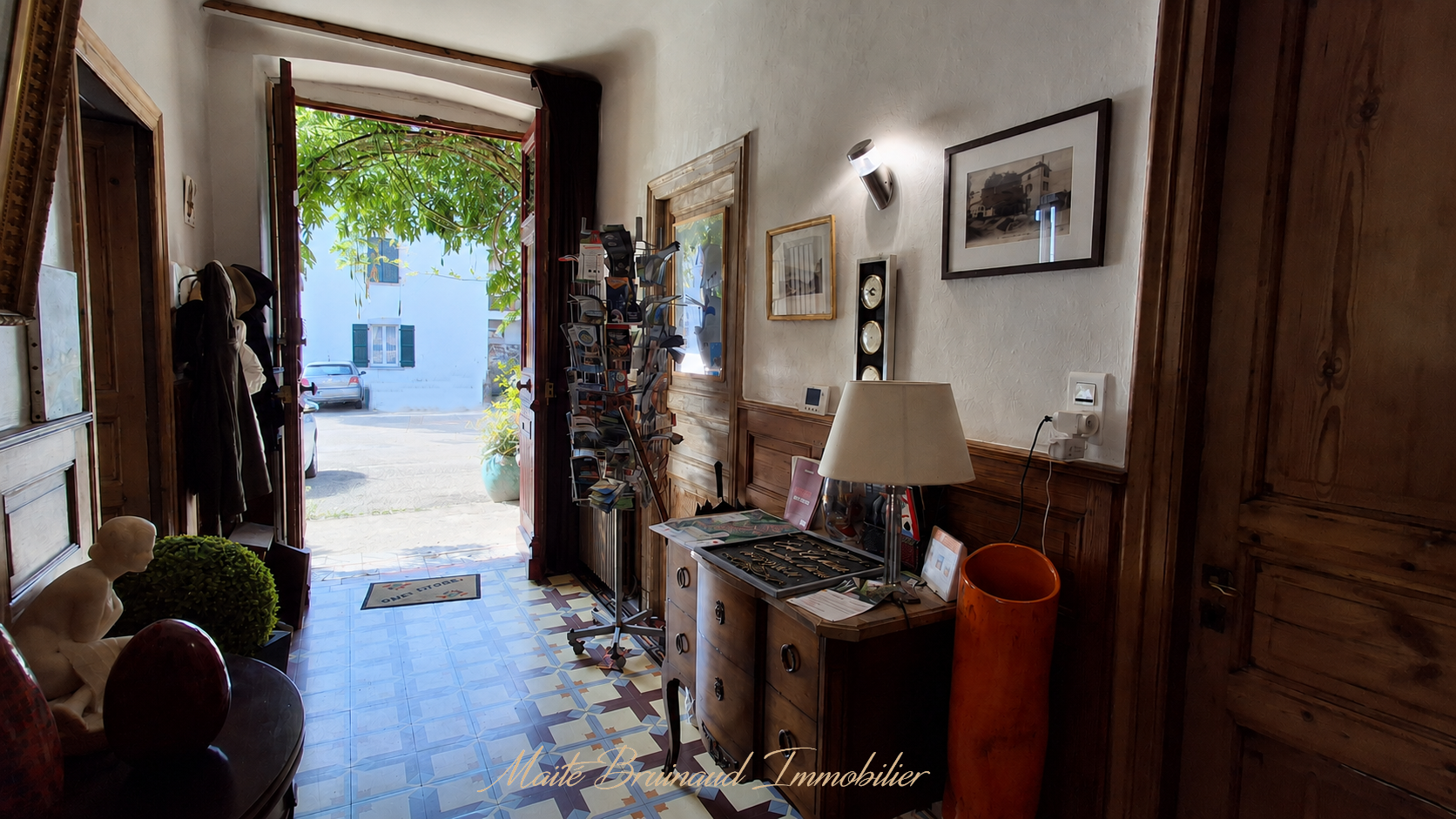 Entrée d'une maison de caractère à Ustaritz avec un sol en carrelage et des murs en bois.