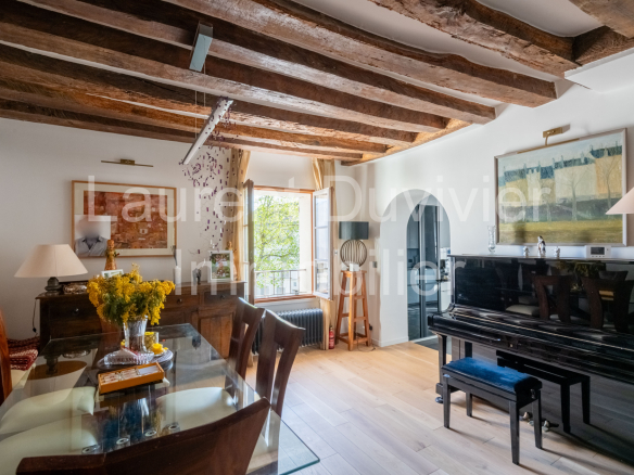 Intérieur d'une maison vigneronne rénovée avec poutres apparentes et piano à queue.