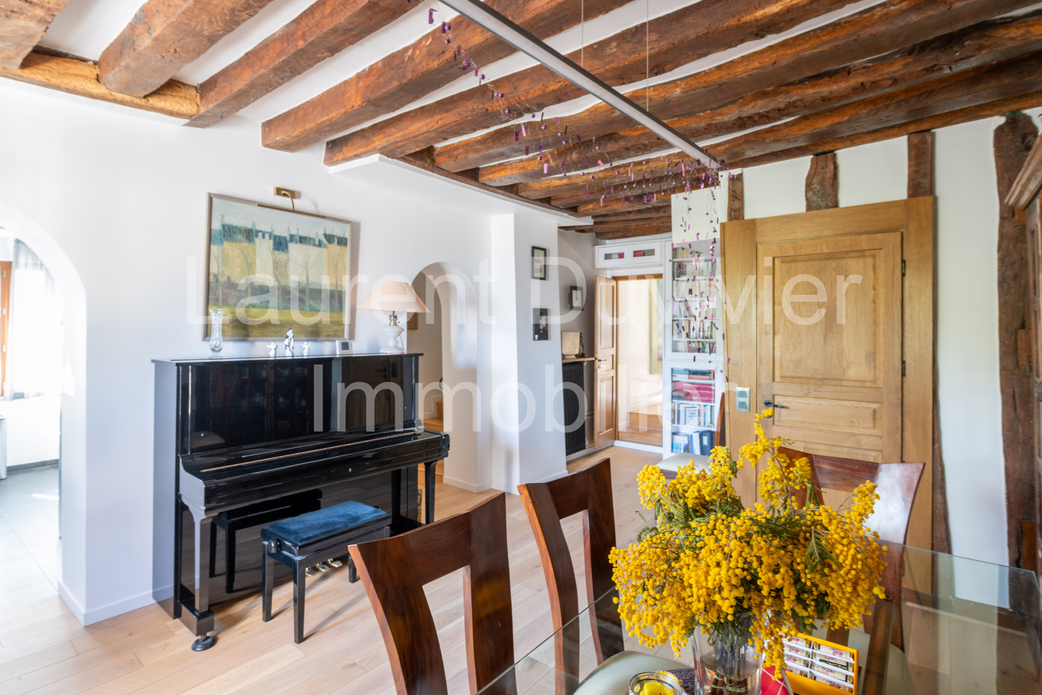 Intérieur d’une maison vigneronne Intérieur d'une maison vigneronne rénovée avec poutres apparentes et piano dans le salon.