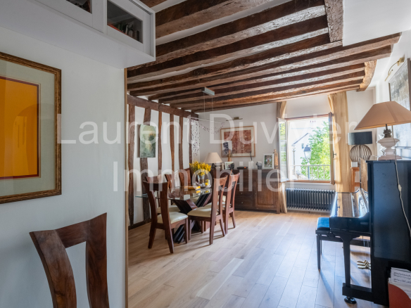 Intérieur d'une maison vigneronne rénovée avec poutres apparentes et mobilier moderne.
