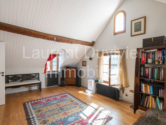 Intérieur d'une maison vigneronne rénovée avec poutres apparentes et bibliothèque à Marly-le-Roi.